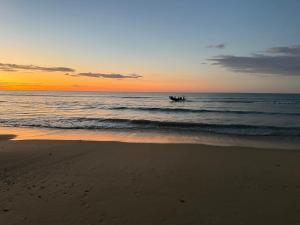 a boat in the water on the beach at sunset at Casablanca in Dwarskersbos