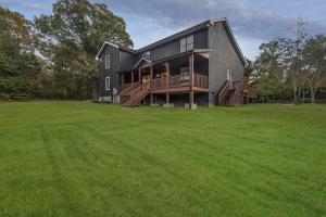 a black house with a large grass field at 5BR Private Ranch Pet Friendly in Wake Forest