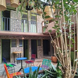 a patio with chairs and a table and a tree at Xelva Hostel & Travel community in San Cristóbal de Las Casas