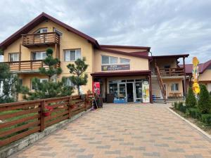 ŢibăneştiVila Onyx的前面有砖瓦车道的建筑