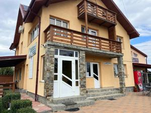 a house with a white door and a balcony at Vila Onyx in Ţibăneşti