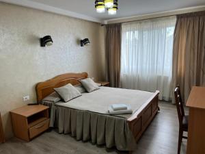 a bedroom with a large bed with two pillows on it at Vila Onyx in Ţibăneşti