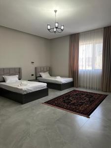 two beds in a large room with a rug at Shahristan Hotel in Aktau +58 photos