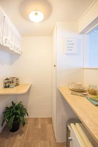 a kitchen with white walls and a wooden counter top at Downtown B&B in Mount Maunganui