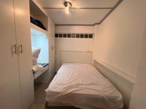 a small bedroom with a white bed in it at The Pearl at Strand in Strand