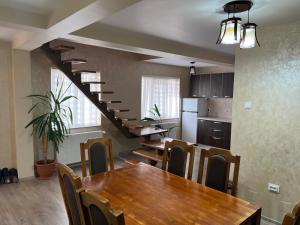 a kitchen and dining room with a table and a staircase at Vila Onyx in Ţibăneşti