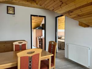 a kitchen and dining room with a wooden table at Vila Onyx in Ţibăneşti +9 photos