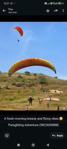 a person flying a parachute in a field at Skyline villa Lonavala in Lonavala