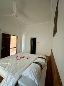 een groot wit bed in een kamer met 2 kussens bij Active Apartments in Paje +1 foto