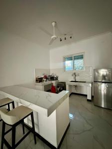 een keuken met een tafel, stoelen en een koelkast bij Active Apartments in Paje