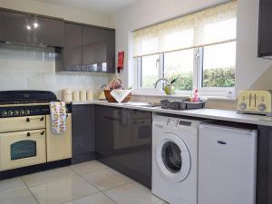 a kitchen with a washing machine and a washer at Bumble Lodge in Llynclys