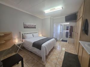 ポロクワネにあるGuest House On Marshallの大きなベッドとバスルームのある寝室