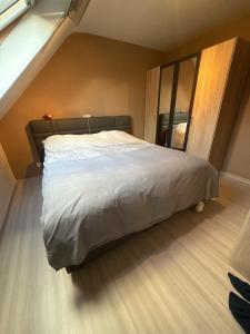 a bedroom with a large bed with a large mirror at Modern Duplex Apartment with terrace view in Stekene