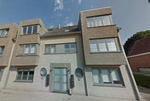 a brick building with a blue door at Modern Duplex Apartment with terrace view in Stekene