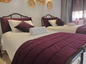 DerouaChambre Aéroport Mohammed 5的紫白色客房的两张床