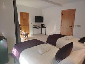 DerouaChambre Aéroport Mohammed 5的有两张床和一台电视的酒店房间 更多9张照片