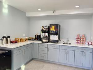 a kitchen with white cabinets and a coffee maker at Royale Inn 老爺客棧 - San Gabriel, Los Angeles in Rosemead