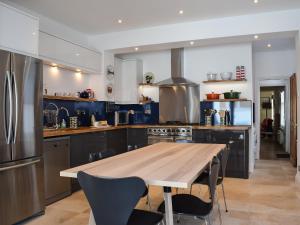 a kitchen with a wooden table and a kitchen with blue cabinets at Lapwing in Yarmouth
