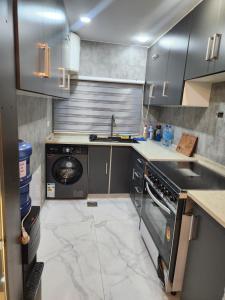 a kitchen with a sink and a washing machine at شقة مفروشة apartment amman alnuzzha in Amman