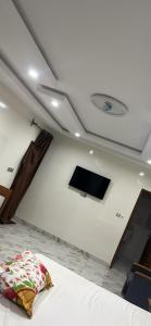 a room with a bed and a flat screen tv at Keur Mame Coumba in Saint-Louis