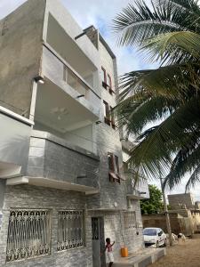 a woman standing in front of a building at Keur Mame Coumba in Saint-Louis +3 photos