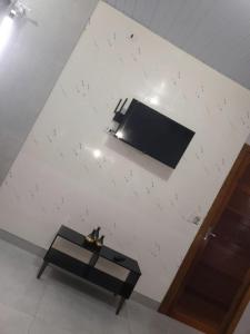 a room with a table and a tv on a wall at Modern cozy, for 5 with air in Guaíra