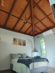 ein Schlafzimmer mit einem Bett und einer Holzdecke in der Unterkunft Casa Boa Energia in Barra Grande