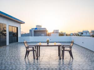 einen Tisch und zwei Stühle auf einer Terrasse in der Unterkunft Nazar Villa in Malavli