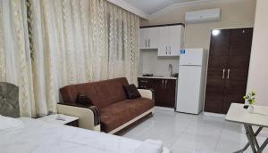 een woonkamer met een bank en een keuken bij Özlem Apart&Pansiyon in Hatay +2 foto's