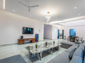 ein großes Wohnzimmer mit einem Sofa und einem TV in der Unterkunft Nazar Villa in Malavli