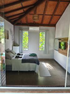 ein Schlafzimmer mit einem Bett und zwei Fenstern in der Unterkunft Casa Boa Energia in Barra Grande