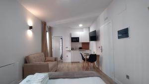 a room with a bed and a couch and a kitchen at Apartamentos Recunchos in Ourense