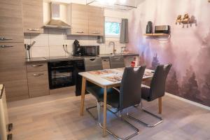 a kitchen with a table and chairs in it at Sakurahuisje in Lanaken +20 photos