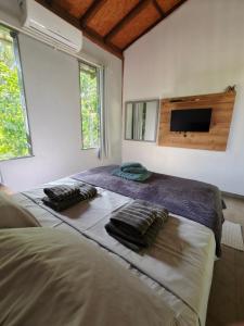 ein Schlafzimmer mit einem großen Bett und einem Fernseher an der Wand in der Unterkunft Casa Boa Energia in Barra Grande + 60 Fotos