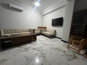 a living room with a couch and a flat screen tv at Nawab's Hotel Balakot in Bālākot