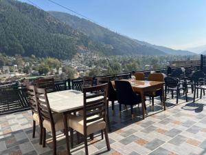 a restaurant with tables and chairs on a roof at Nawab's Hotel Balakot in Bālākot