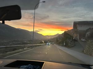 a car driving down a road with a sunset at Maison in Vétroz