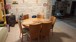 a wooden table and chairs in a living room at הבית במושב in Umm el Shuf