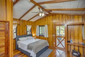 Un dormitorio con una cama y un ventilador de techo. en Kmar Villas, en Placencia Village