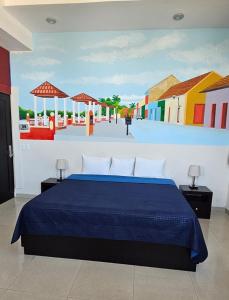 a bedroom with a blue bed with a painting on the wall at Hotel Mágico del Mar in La Paz