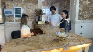 a man and two women standing at a counter in a kitchen at Shahristan Hotel in Aktau