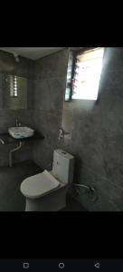 Chaloba Hills Agro Resort في Ajra: حمام مع مرحاض ومغسلة ونافذة