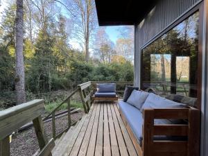 eine Veranda mit einem Sofa auf einer Holzterrasse in der Unterkunft Cabaña Roble - BBQ Home Office Washer Wood Hot Tub in Huiscapi