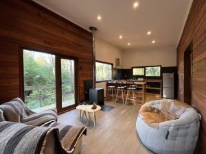 ein Wohnzimmer mit Sofa und Tisch in der Unterkunft Cabaña Roble - BBQ Home Office Washer Wood Hot Tub in Huiscapi