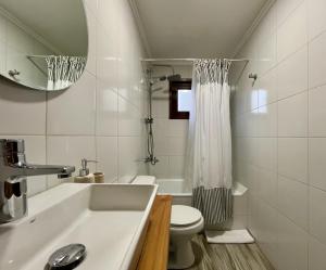 ein Badezimmer mit Waschbecken, Toilette und Spiegel in der Unterkunft Cabaña Roble - BBQ Home Office Washer Wood Hot Tub in Huiscapi + 26 Fotos