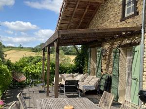 Un patio con un sofá y sillas en una casa. en Domaine du Cammazet, en Lapenne
