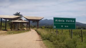 a green street sign next to a dirt road at Pousada Magia da Aldeia in Silva Jardim