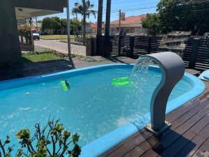 a swimming pool with a water fountain at Casa veraneio 3 quartos com piscina in Xangri-lá