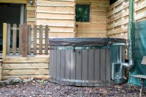 a trash can outside of a house with a fence at Chalet Bos en Pootjes in Lanaken