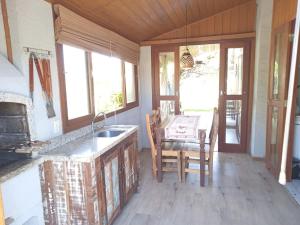 a kitchen with a sink and a table with chairs at Recanto da Natureza in Imbituba +29 photos